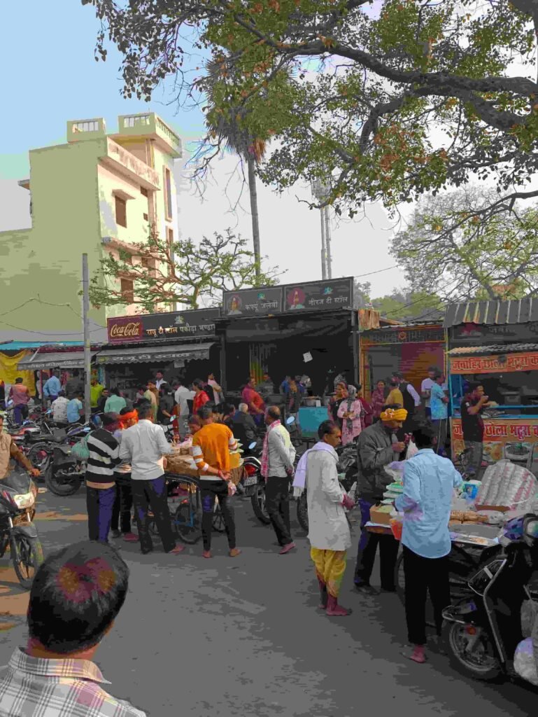 Famous Kohinoor of taste Curfew Jalebi shop in Ayodhya with crowd of people eating during the day.