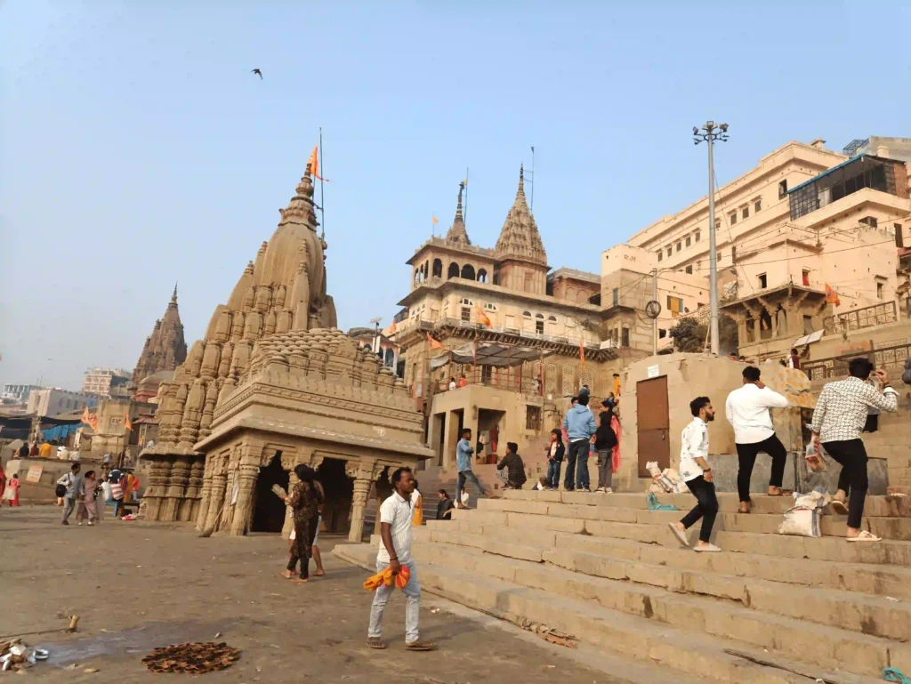 Temple by the river with visitors.  Tower of Pisa