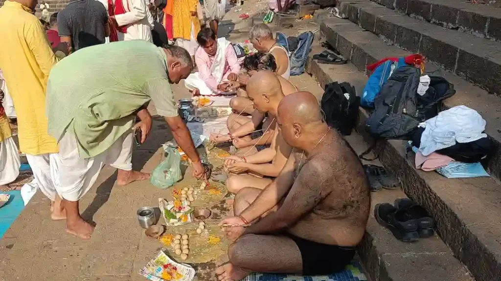 Pandit ji guiding on how to perform pitru pujan at the ghat